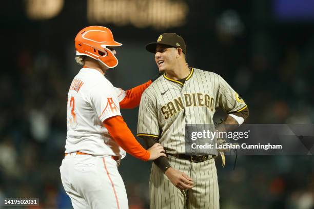 Base runner Joc Pederson of the San Francisco Giants talks with third baseman Manny Machado of the San Diego Padres in the bottom of the eighth...