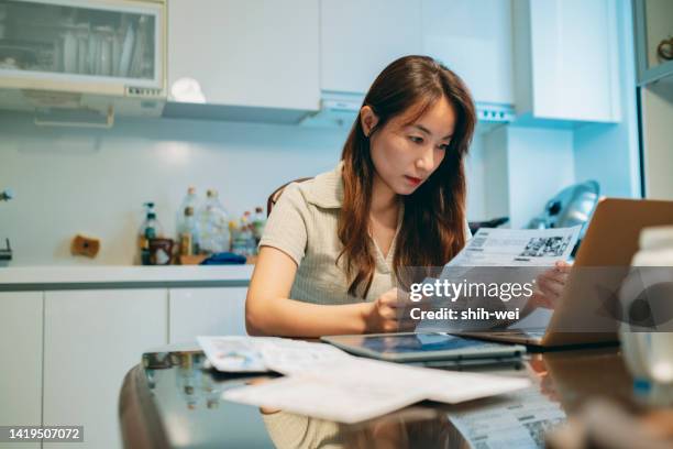 upset woman thinking about high prices while looking at utilities, gas, electricity, rental charges, planning personal budget while sitting in kitchen. - cost of living stock pictures, royalty-free photos & images