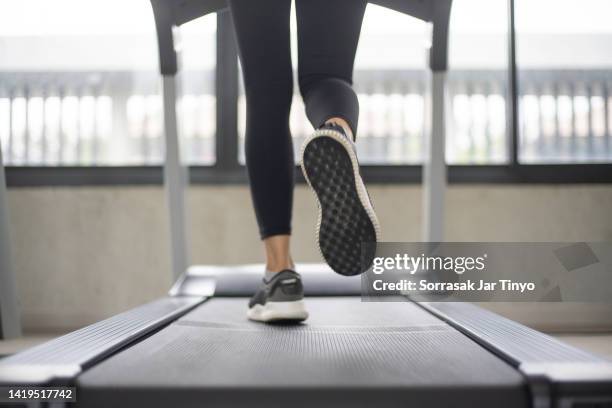 women legs running on treadmill at the fitness gym. - laufband stock-fotos und bilder
