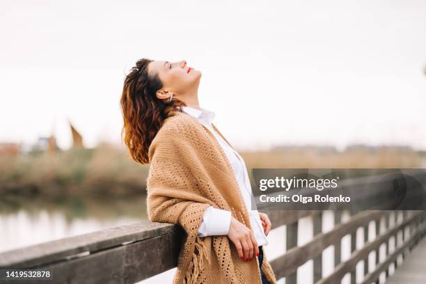 mature woman walk alone in the part at autumn day and breathe with fresh cold air - woman casual stock-fotos und bilder