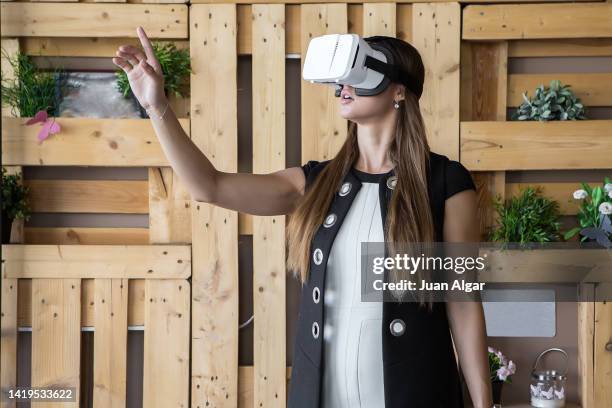 woman in vr glasses touching air and exploring cyberspace - invisível imagens e fotografias de stock