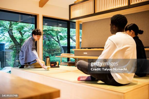 a tea ceremony experience for tourists visiting japan at the guesthouse. - washitsu stock pictures, royalty-free photos & images