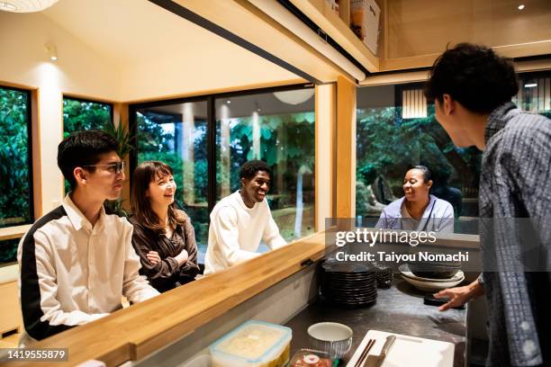 tourists deepening their friendship at the counter of the guesthouse where they stayed during their trip to japan. - public building ストックフォトと画像