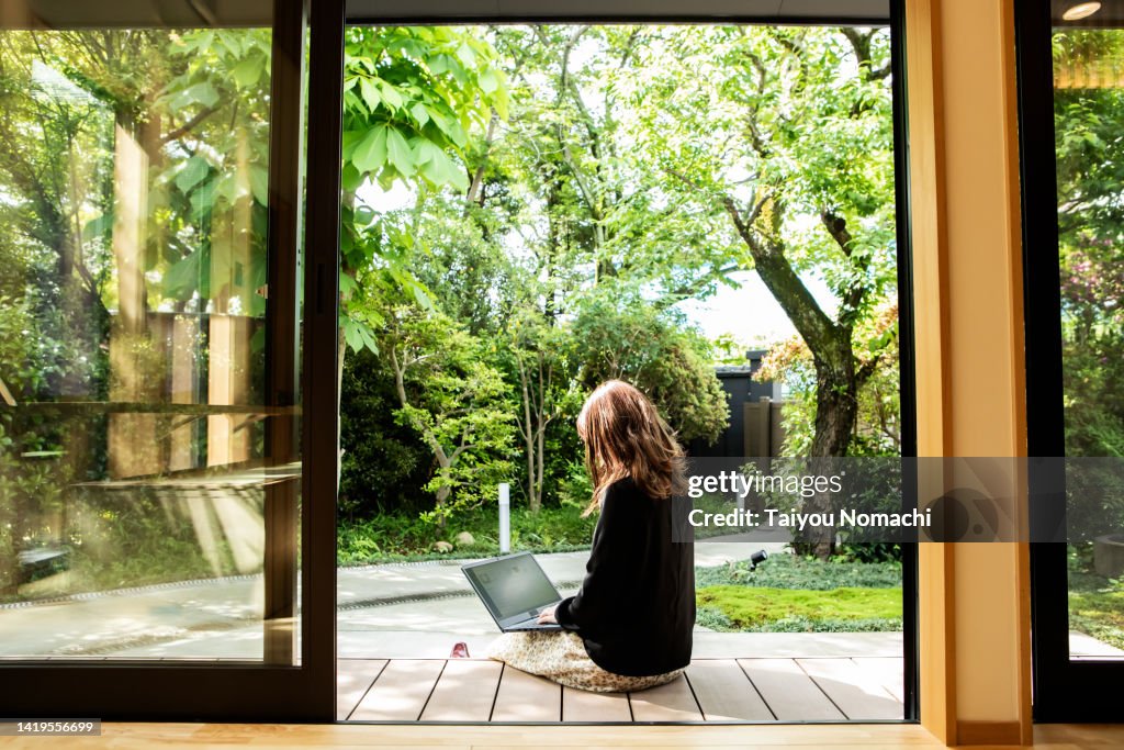 A female guest working on the porch of the guesthouse where she stayed during her trip to Japan.