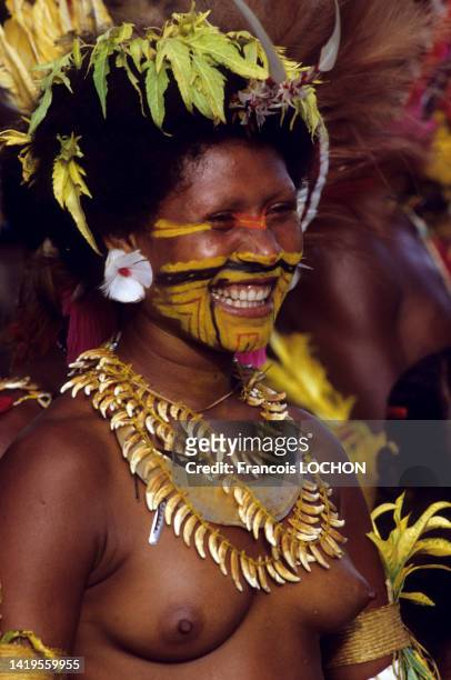 Femme au visage peint et aux seins nus avec un costume traditionnel en Papouasie-Nouvelle-Guinée en mai 1984.