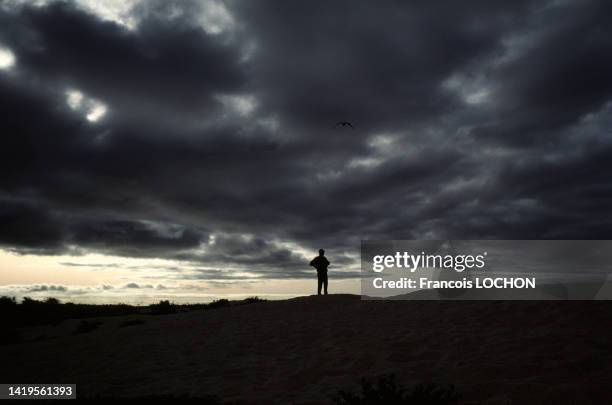 Silhouette d'un touriste sous un ciel sombre et orageux dans les îles Galápagos, en 1992, Equateur.