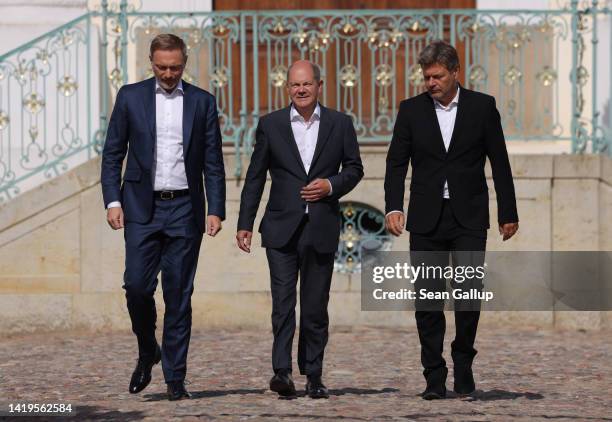 German Chancellor Olaf Scholz , Finance Minister Christian Lindner and Economy and Climate Action Minister Robert Habeck emerge to speak to the media...