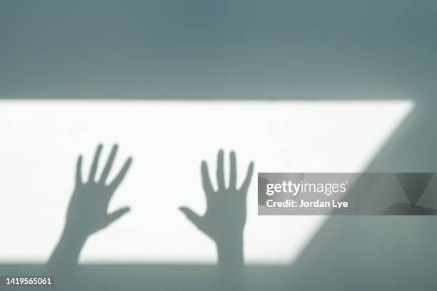 shadow of hands gesturing against wall - magic wand stock-fotos und bilder