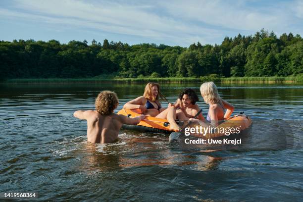 group of friends having fun in water - rubber boat stock pictures, royalty-free photos & images