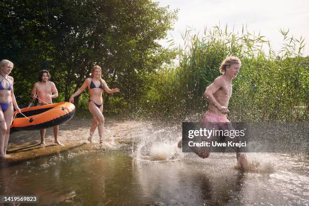 friends splashing into lake together - idyllic lake bildbanksfoton och bilder