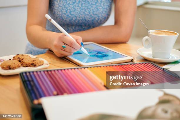 close-up of a young illustrator at work in a coffee shop - ilustrador fotografías e imágenes de stock