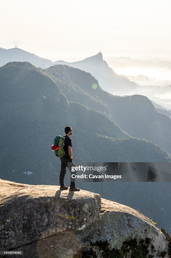 Climber enjoying beautiful view to city from rocky mountain top