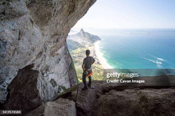 beautiful view to rock climber near steep rocky wall - sao conrado beach stock pictures, royalty-free photos & images