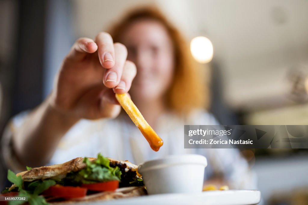 Eintauchen von Pommes frites in Ketchup im Restaurant
