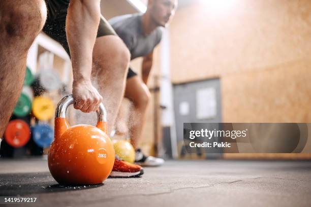 lifting kettlebells - kettle bells stockfoto's en -beelden