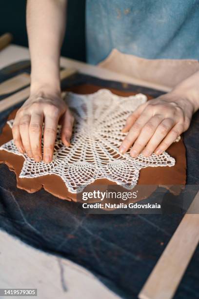 smoothing out lace on rolled clay. making pottery at ceramics master class. handmade pattern for earthenware. concept of art therapy or hobby. creative occupation of faceless craftsperson. professional printmaking technique. vertical, closeup - art therapy stock pictures, royalty-free photos & images