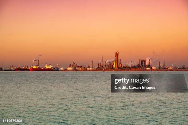 tankers and refinery at sunset at the texas city, texas docks - texas city foto e immagini stock