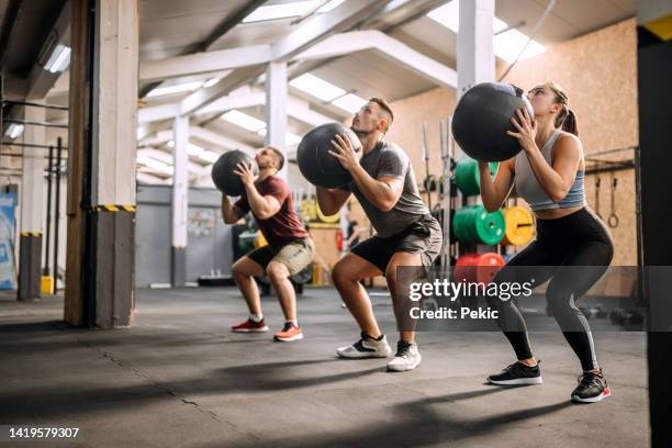 fitness class using heavy weight balls - exercise class stock pictures, royalty-free photos & images