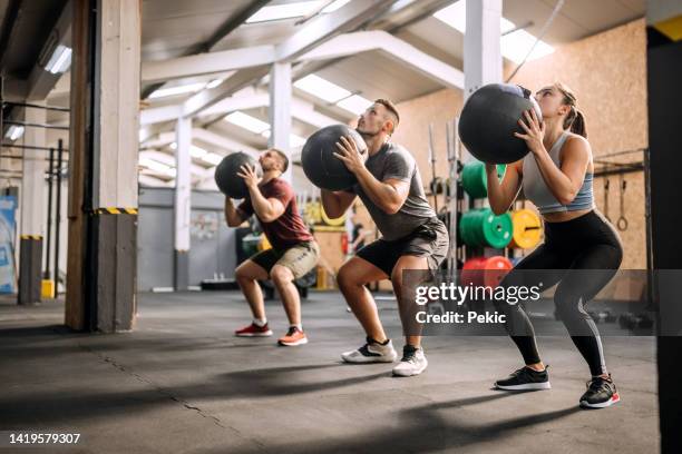 fitness class using heavy weight balls - medicine ball stock pictures, royalty-free photos & images