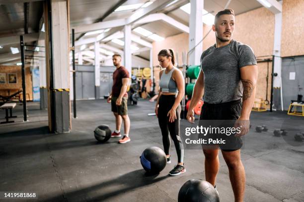 group of athlete people with weighted balls at cross training gym - 3 gym stock pictures, royalty-free photos & images