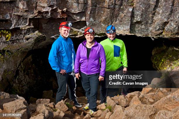 scientists at the entrance of leidarendi lava cave in iceland - spelunking ストックフォトと画像