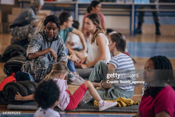 soldiers with civilians after natural disaster - migrant crisis in europe stock pictures, royalty-free photos & images