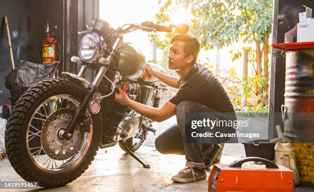 Mechanic Working On Motorcycle At Custom Bike Shop In Bangkok High-Res Stock Photo