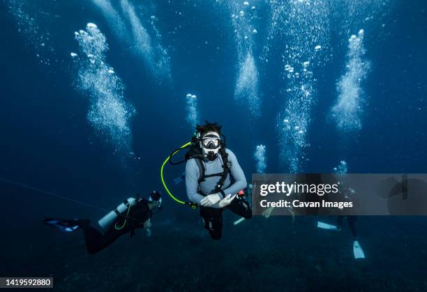 divers performing a mandatory safety stop at the andaman sea - diving equipment stock pictures, royalty-free photos & images