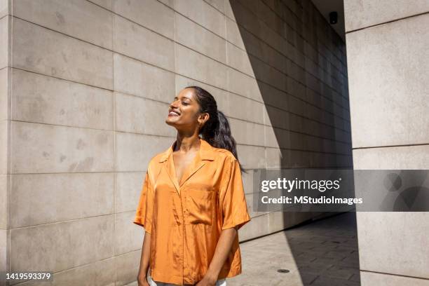 young woman standing in front of the building - confident indian woman stock pictures, royalty-free photos & images