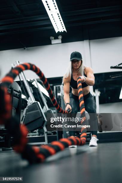 fit woman with blonde hair doing rope workout in gym - saint georges college stock pictures, royalty-free photos & images