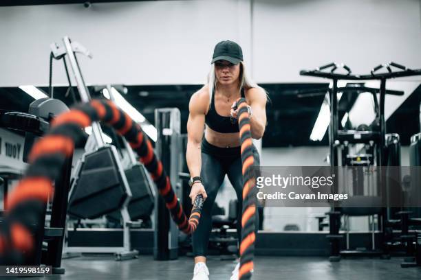 fit woman with blonde hair doing rope workout in gym - saint georges college stock pictures, royalty-free photos & images