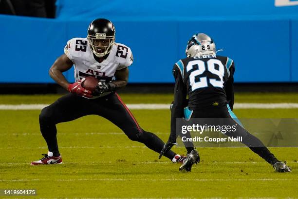 Brian Hill of the Atlanta Falcons attempts to avoid the tackle by Corn Elder of the Carolina Panthers during an NFL game against the Carolina...