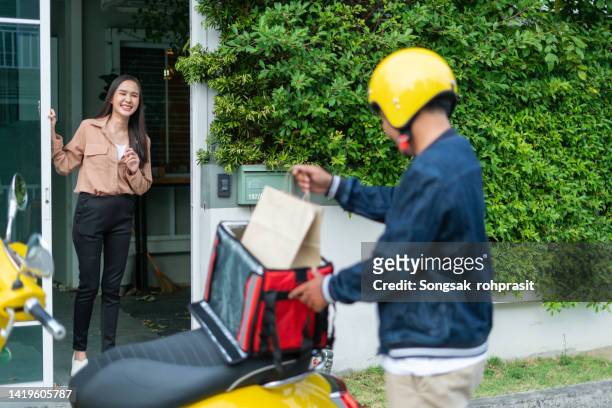 asian chinese delivery man with helmet press door bell for grocery food delivery - door bell stock-fotos und bilder
