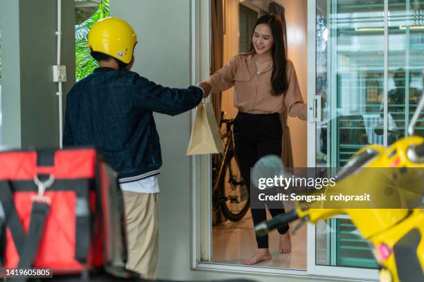 asian chinese delivery man with helmet press door bell for grocery food delivery - door bell fotografías e imágenes de stock