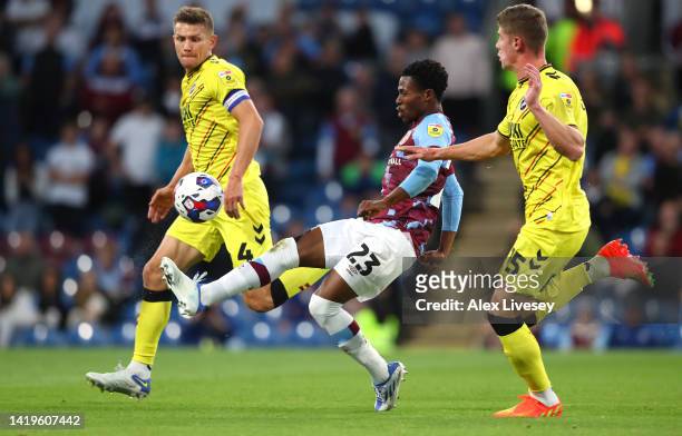 Nathan Tella of Burnley controls the ball under pressure from Charlie Cresswell and Shaun Hutchinsonof Millwall during the Sky Bet Championship...