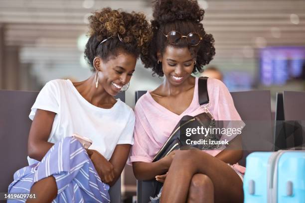 female friends waiting for the flight - airport sitting family stock pictures, royalty-free photos & images