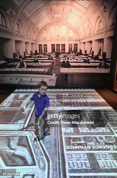 Boy runs across an interactive projection of the Harland and Wolff drawing Office at the Titanic Belfast visitor attraction on March 27, 2012 in...