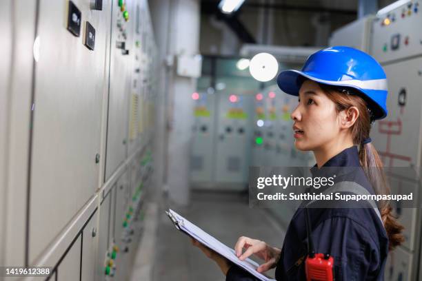 asian female electrician engineer working in control room - chonburi province stock photos et images de collection