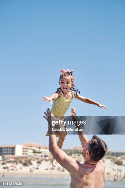 father tossing his daughter in air - dad throwing kid in air stockfoto's en -beelden