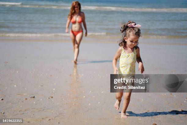 mother and daughter walking on the beach - beach footprints stock pictures, royalty-free photos & images