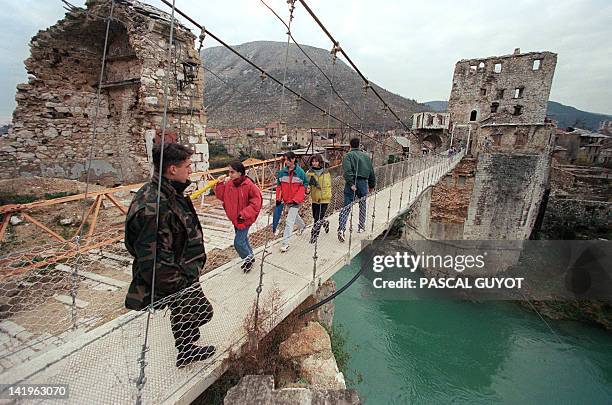 Bosnian soldier is pictured 17 December on a hanging footbridge which replaced the old bridge of Mostar . The Mostar bridge which was bombed out in...