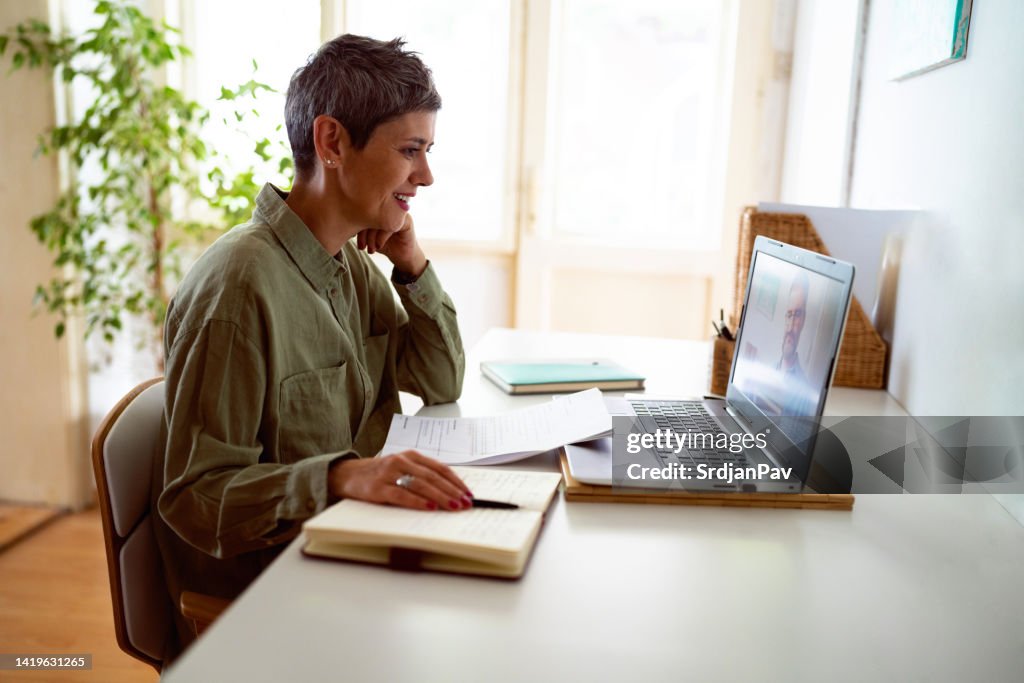 Woman following online courses on her laptop at home