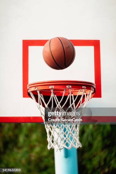 scoring during a basketball game - ball in hoop - basketball court texture stock pictures, royalty-free photos & images