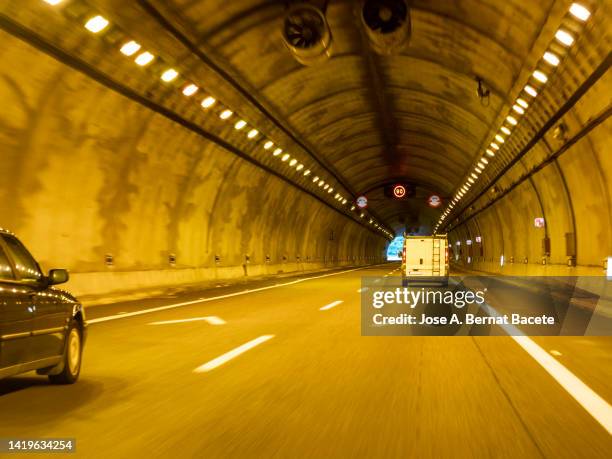 car point of view driving, cars moving through a lighted tunnel on a highway. - light at the end of the tunnel car stock pictures, royalty-free photos & images