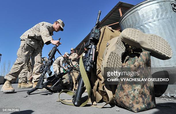 Servicemen pack their gear near a plane before their departure to Afghanistan from the US transit center Manas, 30 km outside the Kyrgyzstan's...