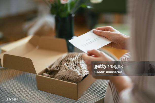 femme anonyme lisant une note d’une boîte cadeau (espace de copie) - boîte au lettre photos et images de collection