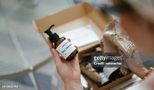 femme anonyme tenant une boîte cadeau et regardant des produits cosmétiques de beauté à l’intérieur (espace de copie) - cosmetique naturel photos et images de collection