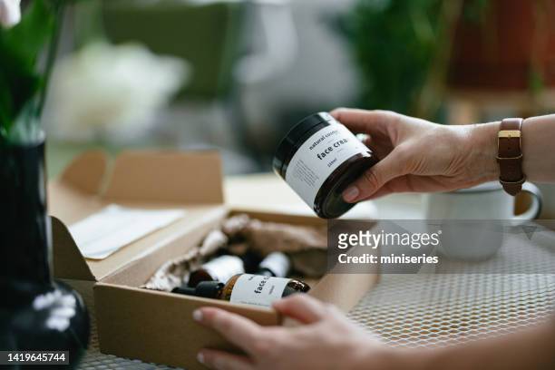 anonymous woman holding a gift box and looking at beauty cosmetics products inside (copy space) - cosmetics box stock pictures, royalty-free photos & images