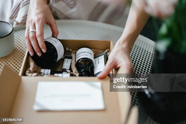 anonymous woman holding a gift box and looking at beauty cosmetics products inside (copy space) - art and craft stock pictures, royalty-free photos & images