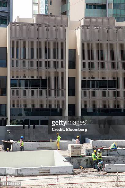 Construction workers are seen building new apartment blocks at the Al Muneera development during a media tour organized by Aldar Properties PJSC, Abu...